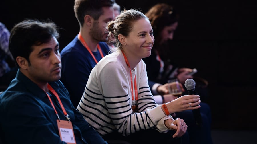 Founder presenting on a spotlit conference stage